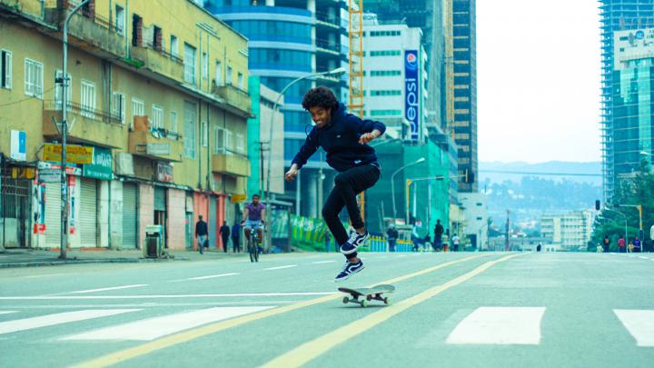 Skateboarder jumps in the middle of a city street in Addis Ababa