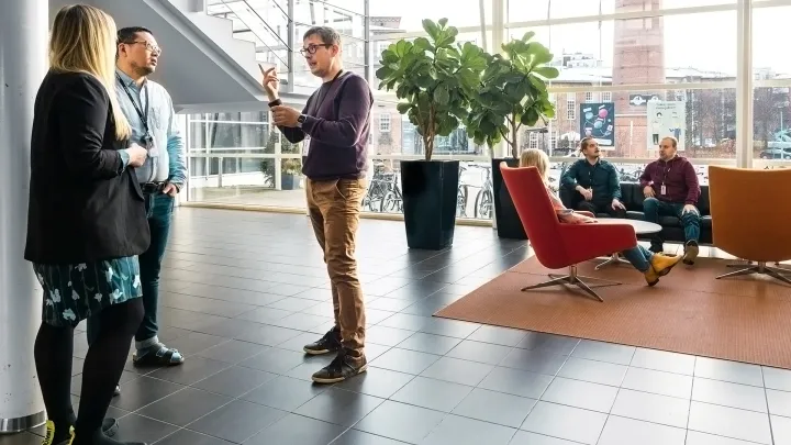 Ihmiset keskustelevat keskenään aulatilassa. 