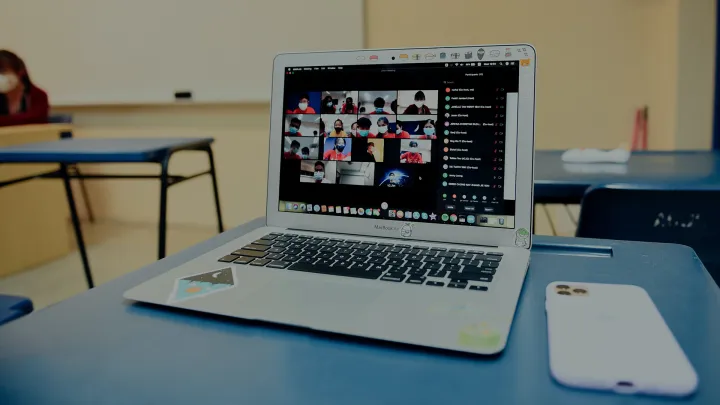 Kannettava tietokone ja puhelin luokassa pöydällä