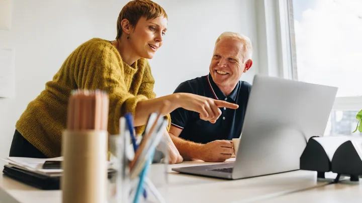 Kollegat työskentelemässä tietokoneen ääressä