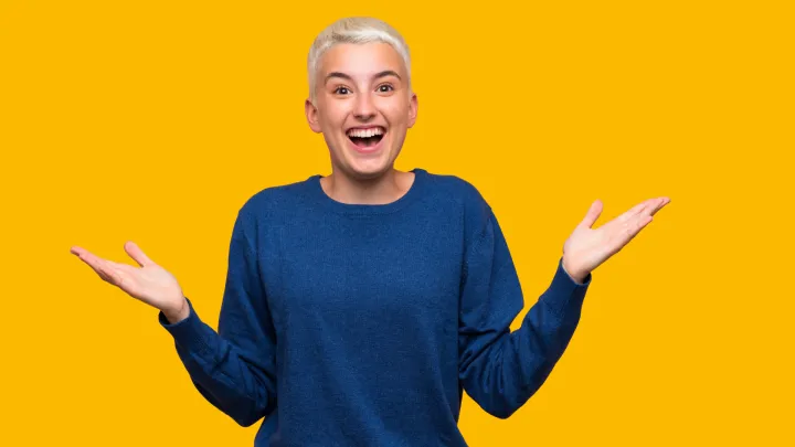 Innostunut näköinen vaalea nainen keltaisella taustalla