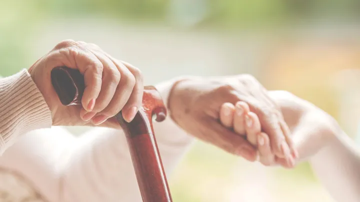Vanhan ihmisen ja nuoren ihmisen kädet pitelemässä toisiaan.
