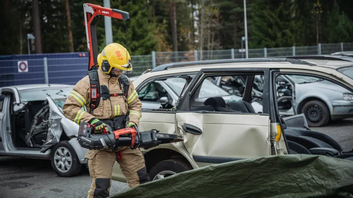 Pelastaja purkamassa autoa eksoskeletonia hyödyntäen.